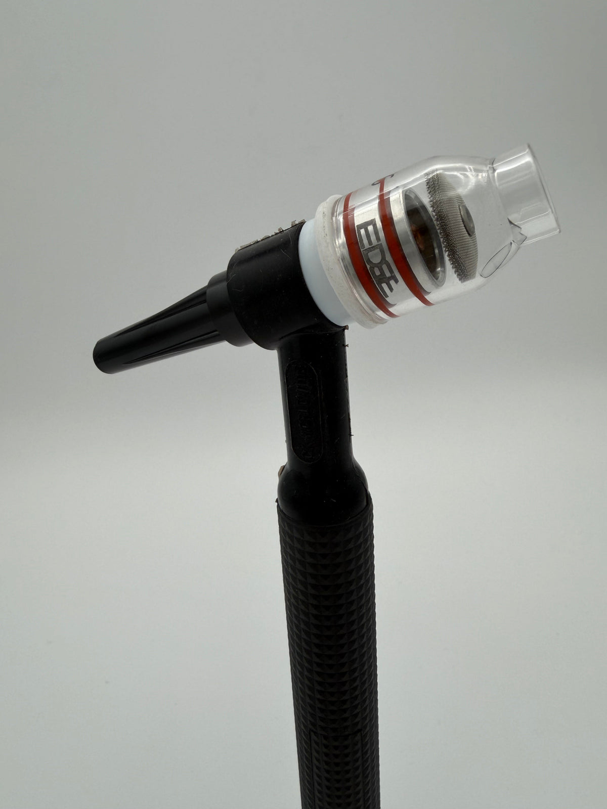 EDGE clear welding cup attached to black TIG welding torch against grey background